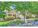 Charming home with mature trees, a two-car garage, lush landscaping, and a welcoming front porch at 8919 Oransay Way, Charlotte, NC 28278