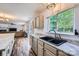 Kitchen with granite counters, black sink, stainless dishwasher and view into adjacent living room at 8919 Oransay Way, Charlotte, NC 28278