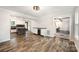 Basement area with bar, wood-look flooring, and a view into the main living space with exposed beams at 8936 Rittenhouse Cir, Charlotte, NC 28270