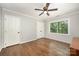 Bedroom featuring two closets, a ceiling fan, and a window overlooking the green foliage outside at 8936 Rittenhouse Cir, Charlotte, NC 28270