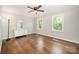 Bright bedroom with hardwood floors, ceiling fan, and ample natural light from two windows at 8936 Rittenhouse Cir, Charlotte, NC 28270