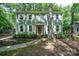 Charming two-story home with sage green siding, white shutters and a red front door surrounded by lush landscaping at 8936 Rittenhouse Cir, Charlotte, NC 28270
