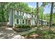 Side view of a sage green two-story home with a well-maintained yard and mature trees providing shade at 8936 Rittenhouse Cir, Charlotte, NC 28270