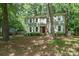 Traditional two-story home with a round window detail, surrounded by mature trees and a lush green lawn at 8936 Rittenhouse Cir, Charlotte, NC 28270