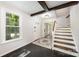 Bright foyer featuring dark tile flooring, wooden stairs, and a large window allowing for natural light at 8936 Rittenhouse Cir, Charlotte, NC 28270