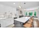 Well-lit kitchen with modern appliances, white cabinets, a spacious island, and stylish pendant lights at 9809 Hanover Hollow Dr, Charlotte, NC 28210