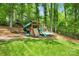 Backyard playground with slide, climbing wall, and swing set surrounded by lush greenery at 9809 Hanover Hollow Dr, Charlotte, NC 28210