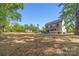 Expansive home backyard featuring mature trees, fresh straw and an inviting outdoor space at 1 Linestowe Dr, Belmont, NC 28012