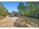 View of the two-story home with a large yard and a backdrop of lush greenery at 1 Linestowe Dr, Belmont, NC 28012