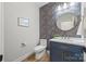 Powder room with decorative wallpaper, round mirror, and navy blue vanity cabinet at 1 Linestowe Dr, Belmont, NC 28012