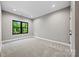 A bright bedroom featuring soft carpet, a modern window with green outdoor views, and recessed lighting at 1 Linestowe Dr, Belmont, NC 28012