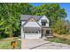 Charming two-story home featuring a white facade, a garage, and a welcoming front porch at 1 Linestowe Dr, Belmont, NC 28012