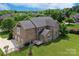 Aerial view of an impressive brick home highlighting the back deck, lush lawn, and mature trees at 101 Stonehurst Ln, Waxhaw, NC 28173