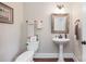 Stylish powder room with pedestal sink, decorative mirror, and elegant fixtures at 101 Stonehurst Ln, Waxhaw, NC 28173