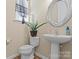 Charming powder room with pedestal sink, decorative mirror, and neutral tones at 10116 Garman Hill Dr, Charlotte, NC 28214