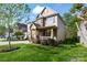 Charming home with stone accents, covered porch, white railing, and lush, green lawn at 10116 Garman Hill Dr, Charlotte, NC 28214