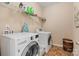 Laundry room featuring tile flooring, modern appliances, and storage shelves at 10116 Garman Hill Dr, Charlotte, NC 28214