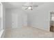 Spacious bedroom with neutral carpet, ceiling fan, and natural light streaming through the windows at 11011 Alderbrook Ln, Charlotte, NC 28270
