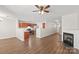Open-concept living area flowing into a kitchen with a fireplace and hardwood floors at 11011 Alderbrook Ln, Charlotte, NC 28270