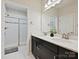 Bathroom features a double sink vanity with white marble counters and a glass shower door, creating a clean and modern space at 12641 Glowing Peak Rd, Huntersville, NC 28078