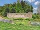 Bryton community entrance featuring a stone sign, lush landscaping, and colorful flower beds at 12641 Glowing Peak Rd, Huntersville, NC 28078
