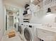 Well-organized laundry room with modern appliances, ample storage shelves, and sink, offering convenience and functionality at 12641 Glowing Peak Rd, Huntersville, NC 28078