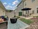 Inviting outdoor patio with comfortable seating, a fire pit, an umbrella covered table perfect for relaxation at 12641 Glowing Peak Rd, Huntersville, NC 28078