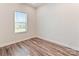 Bright, minimalist bedroom featuring wood floors and a window. It is painted with neutral walls, offering a spacious area at 13210 Kenworth Rd, Charlotte, NC 28278