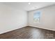 Bright, minimalist bedroom with wood floors and windows for natural light, neutral walls, and ample space at 13210 Kenworth Rd, Charlotte, NC 28278