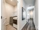 Modern laundry room with stainless steel appliances, shelving, and access to hallway at 13210 Kenworth Rd, Charlotte, NC 28278