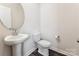Bright powder room with a pedestal sink, round mirror, and modern toilet at 13210 Kenworth Rd, Charlotte, NC 28278