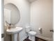 Well-lit powder room features a round mirror, pedestal sink, and modern fixtures at 13210 Kenworth Rd, Charlotte, NC 28278