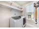 Laundry room equipped with washer, dryer, shelving, and a vacuum wall mount at 1507 Riverwalk Pkwy, Rock Hill, SC 29730