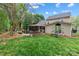 Landscaped backyard with a stone patio, dining area, grill, and lush green lawn at 1509 Kirkbridge Ct, Matthews, NC 28105