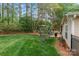 Spacious backyard with a stone patio, mature trees, and lush green lawn at 1509 Kirkbridge Ct, Matthews, NC 28105