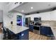 Open-concept kitchen with stainless steel appliances, island, and blue and white cabinets at 1509 Kirkbridge Ct, Matthews, NC 28105