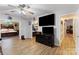 Open living room showcasing hardwood floors, a ceiling fan, and an open doorway to the main bedroom at 1509 Kirkbridge Ct, Matthews, NC 28105