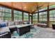 Cozy screened porch with comfortable seating, ceiling fan, and wooded views at 1509 Kirkbridge Ct, Matthews, NC 28105