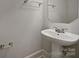 Clean bathroom featuring a pedestal sink, carpeted floor and a towel rack at 151 Harper Lee St, Davidson, NC 28036