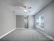 This bedroom has a ceiling fan, a double window, and neutral colored carpet at 151 Harper Lee St, Davidson, NC 28036