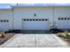 Three car garage with white doors and a large driveway at 151 Harper Lee St, Davidson, NC 28036