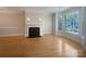 Bright living room featuring hardwood floors, a decorative fireplace, and abundant natural light from the large windows at 151 Harper Lee St, Davidson, NC 28036