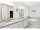 Elegant bathroom featuring a double vanity, soaking tub, and walk-in shower at 15108 Autumn Sage Dr, Charlotte, NC 28278