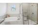 Bright bathroom featuring a soaking tub, tiled shower, and decorative ladder at 15108 Autumn Sage Dr, Charlotte, NC 28278