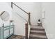 Carpeted staircase with wood railing, leading to the upper level with natural light at 15108 Autumn Sage Dr, Charlotte, NC 28278