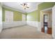 Well-lit carpeted bedroom has wainscoting on the walls, large windows, and white trim at 16919 Hedgerow Park Rd, Charlotte, NC 28277
