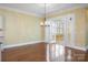 Elegant dining room with hardwood floors, crown molding, a chandelier, and french doors leading to a sunroom at 16919 Hedgerow Park Rd, Charlotte, NC 28277