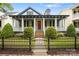 Charming home with a black fence, landscaped yard, and a covered porch with white columns and a red front door at 16919 Hedgerow Park Rd, Charlotte, NC 28277