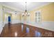 Bright living room with hardwood floors, crown molding, and a chandelier, showcasing the elegant interior at 16919 Hedgerow Park Rd, Charlotte, NC 28277
