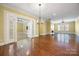 Spacious living room with hardwood floors, a fireplace, and views of the adjacent sunroom through elegant french doors at 16919 Hedgerow Park Rd, Charlotte, NC 28277